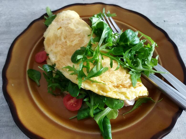 Pyszny omlet z ulubionymi dodatkami to pomysł na sycące śniadanie. Kliknij w galerię i zobacz, jak prosto go przygotować. Przesuwaj zdjęcia strzałkami