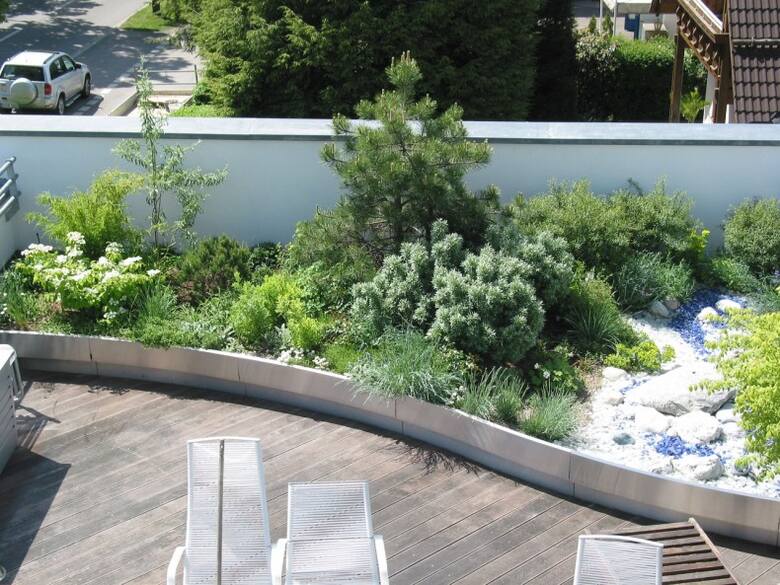 Na dachu płaskim z attyką można urządzić ogród. Wymaga to wykonania warstw dachu zielonego.