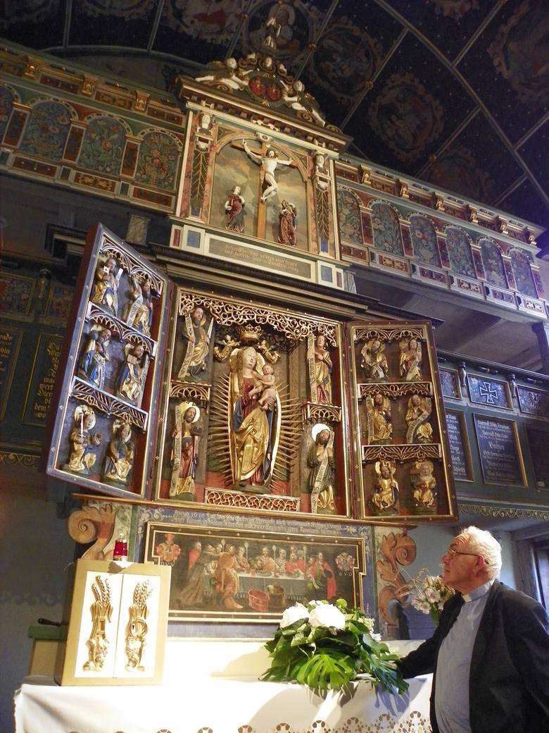 Ksiądz proboszcz i zarazem kustosz Olgierd Banaś przed ołtarzem w kościele w Klępsku. Ołtarz to połączenie kultu katolickiego w części środkowej oraz luterańskiego w częściach dolnej i górnej.