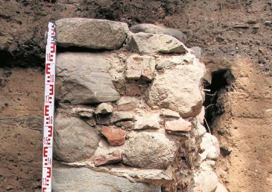 Badacze odkryli też fragment średniowiecznego muru, który był częścią budowli powstałej na już istniejącym cmentarzu.