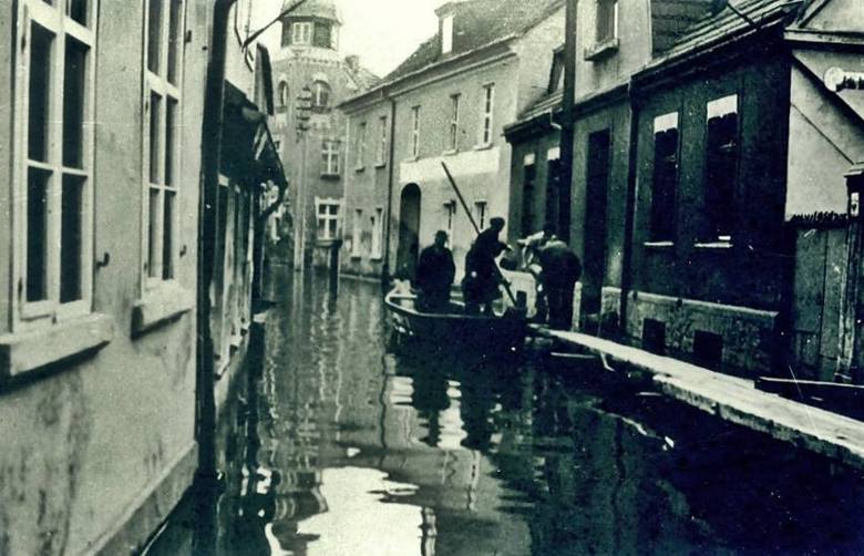 Powódź na wąskiej ulicy Grobla (obecne numery 54 oraz 56). Mieszkańcy korzystali z łódek.