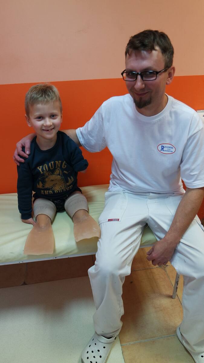 Rzeszowskie Zakłady Ortopedyczne wykonały protezy płetwy dla  Oliwiera. Na zdjęciu: chłopiec i Tomasz Kot, technik ortopeda