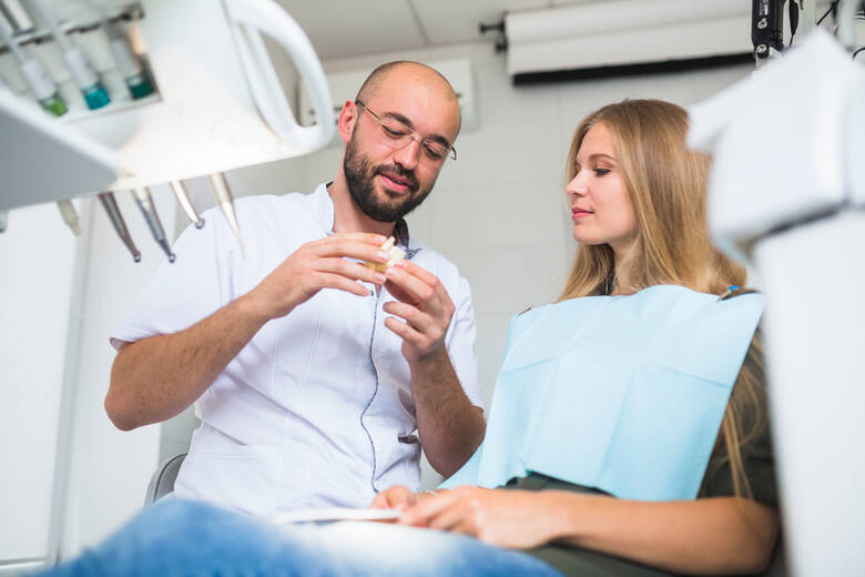Stomatolog pokazuje zęby pacjentce