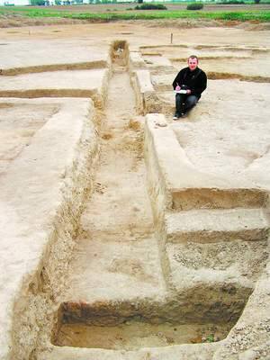 Fot. Arkadiusz Gancarz: Adam Ostasz, archeolog pracujący w Rębielczu pokazuje pozostałości jednego z odkopanych domów.