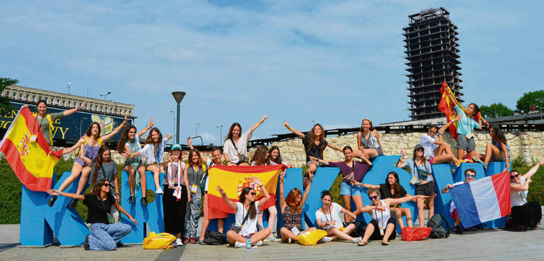Ogromny, styropianowy napis „ŚDM KRAKÓW” stojący na rondzie Mogilskim jest głównym miejscem, w którym fotografują się pielgrzymi. Na zdjęciu grupa młodych ludzi z Hiszpanii i Francji, którą spotkaliśmy w drodze na katechezy. 