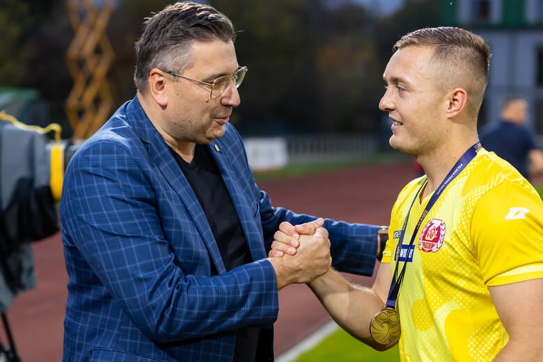 Prezes Znicza Pruszków, Marcin Grubek gratuluje medalu Piłkarskiego Orła września na Mazowszu, Maciejowi Firlejowi