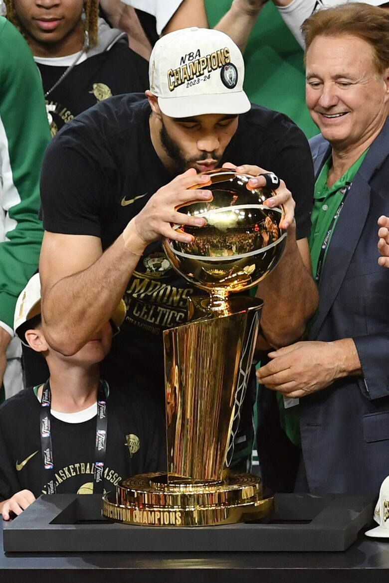 Mały napastnik Boston Celtics Jayson Tatum całuje mistrzowskie trofeum Larry'ego O’Briena