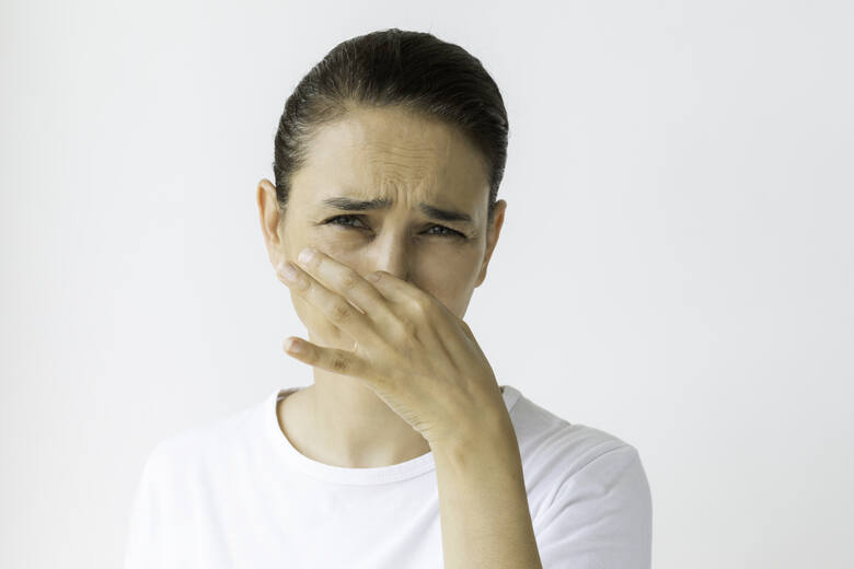 Kobieta zasłaniająca nos przed nieprzyjemnym zapachem