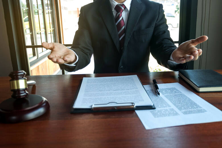 prawnik przedstawia klientowi dokumenty umowy na stole w biurze.