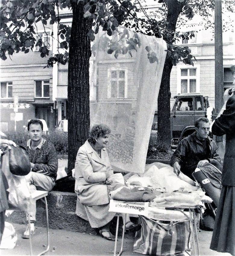 Uliczne stragany z firanami eksponowanymi na drzewach deptaku al. Wojska Polskiego wczesną jesienią 1990 roku 