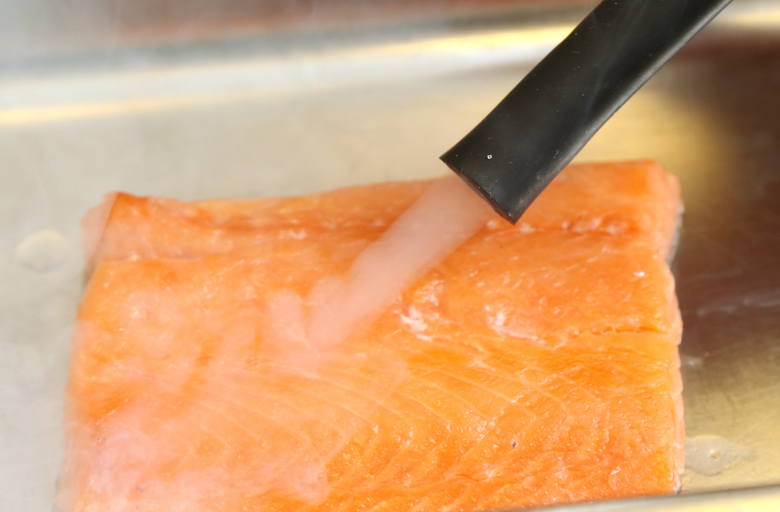Rybę dzielimy na cztery porcje, oczyszczamy i osuszamy. Piekarnik rozgrzewamy do 100 stopni Celsjusza, wstawiamy naczynie z wodą, a następnie rybę. Pieczemy