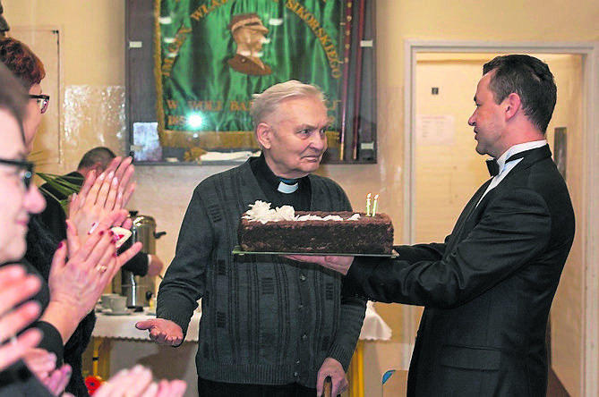 Dwie świeczki na torcie zdmuchnął pomysłodawca i patron chóru ksiądz profesor Jan Chwałek (w środku)