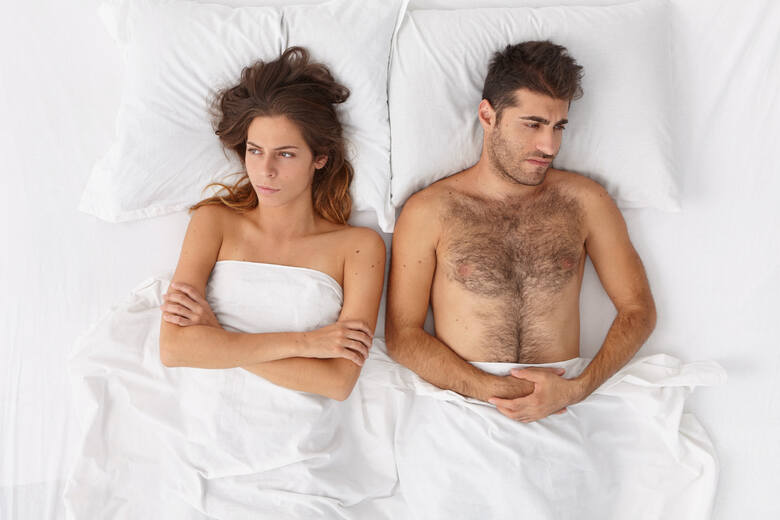 Para w łóżku patrząca w różne strony