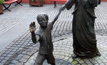 Przechodnie przybijają "piątki" z chłopcem z rzeźby-fontanny