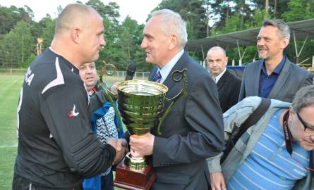 Grający trener bodzentynian Tomasz Dymanowski (z lewej) odbiera główne trofeum od prezesa Świętokrzyskiego Związku Piłki Nożnej Mirosława Malinowski