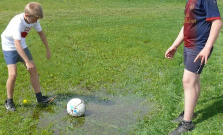 Uczniowie szkoły w Kurzelowie muszą chodzić po kałużach i moczyć buty, gdy im wpadnie piłka do wody stojącej na boisku.
