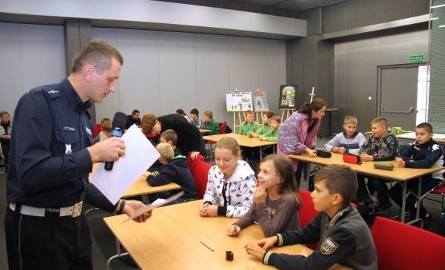 Uczniowie ze szkoły w Kowali odbierają test z rąk policjanta Mariusza Bednarskiego.