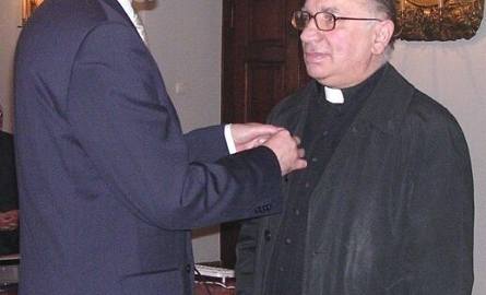 (od prawej) Józef Bukowiec, proboszcz parafii w Padwi Narodowej, odbiera złotą odznakę od Jana Kurpa, wojewody podkarpackiego.