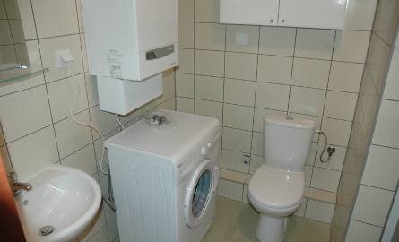 Łazienka wyposażona jest m. in. w pralkę i kabinę prysznicową.
