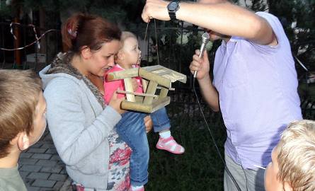 Najmłodsza uczestniczka festynu Małgosia Klimek ( ma rok i 5 miesięcy) otrzymuje w nagrodę od Piotra Rohde karmnik dla ptaszków