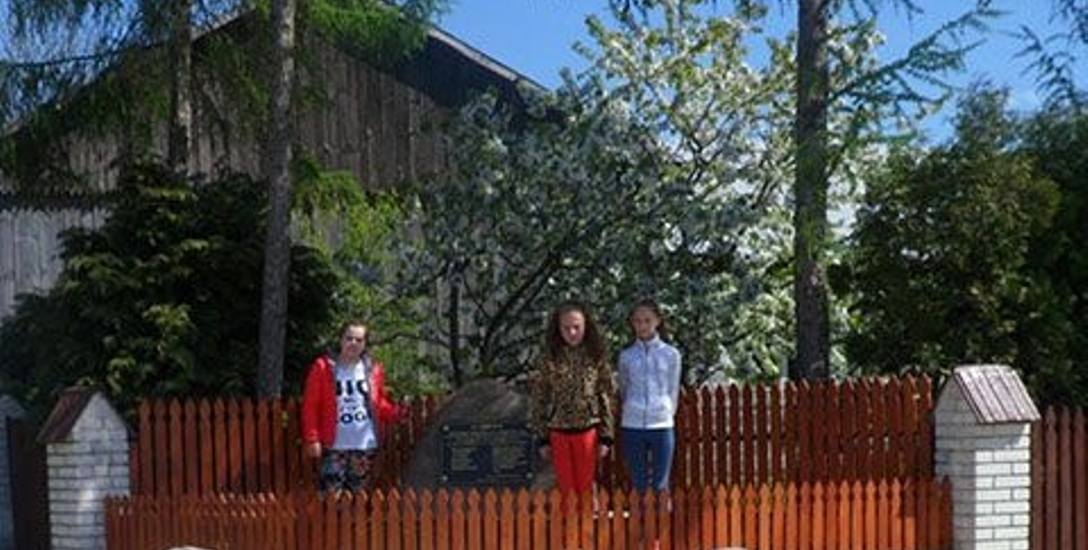 Uczniowie Szkoły Podstawowej imienia Jana Brzechwy w Ratajach Słupskich w powiecie buskim przed pomnikiem upamiętniającym przysięgę złożoną przez członków