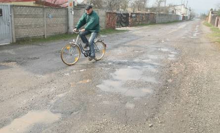 Rowerzyści, aby ominąć brakujący fragment ścieżki rowerowej muszą nadrabiać drogi i jechać pełną dziur ulicą Kadena.