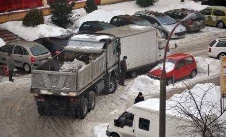 Samochód dostawczy zablokował drogę i ciężarówka, która miała wywozić śnieg, nie może przejechać. Widać bezsilność kierowcy ciężarówki, któremu nie pozostaje
