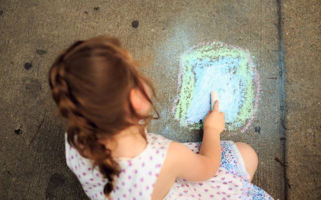 Dzieci uwielbiają rysować kredą po chodniku.