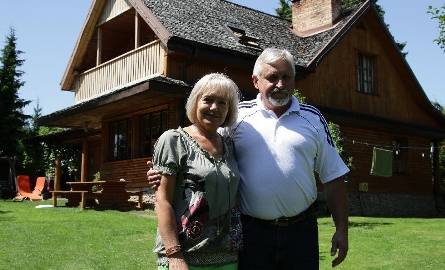 Irmina i Andrzej Norwowie na tle starego domu, który po remoncie służy wczasowiczom