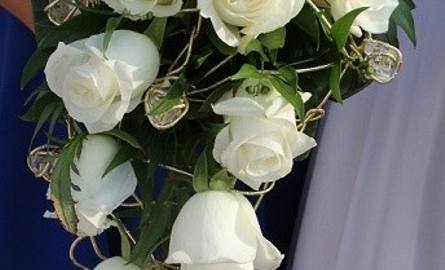 Klasyczna wiązanka z białych róż. W tym bukiecie zastosowano konstrukcję ze złotego drutu, z przezroczystymi kryształkami. Róże najbardziej pasują do