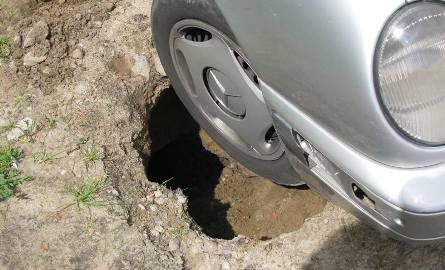 Pod osobówką zapadł się asfalt. Samochód ugrzązł w dziurze (zdjęcia)