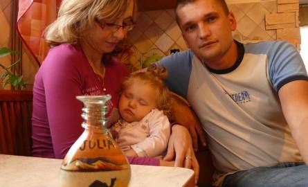 Andrzej z żoną Bernadettą i córeczką Julią, a na pierwszym planie pamiątka z Syrii – butelka z obrazkiem z piasku.