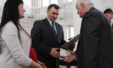 Wiceminister Włodzimier Karpiński wręcza promesę burmistrzowi Niska Julianowi Ozimkowi.