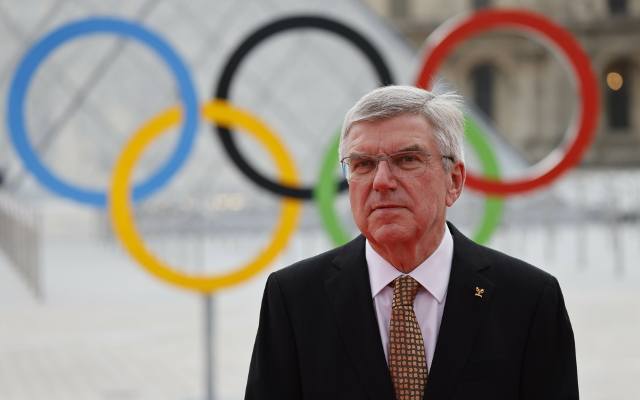 Paryż - przewodniczący MKOl. Thomas Bach pobiegł z ogniem olimpijskim