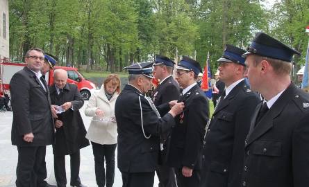 Moment dekoracji strażaków srebrnymi medalami "Za Zasługi dla Pożarnictwa".