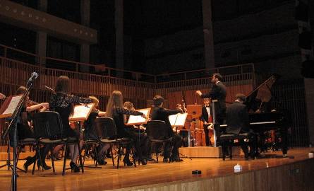 Przemyslaw Zych dyryguje a orkiestra gra