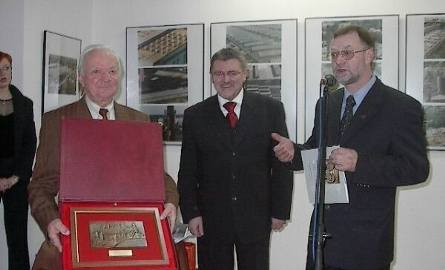 Longin Łępicz pokazuje płaskorzeźbę Ostrowca, którą otrzymał od prezydenta Jan Szostaka, obok prezydent i kustosz galerii Andrzej Łada.