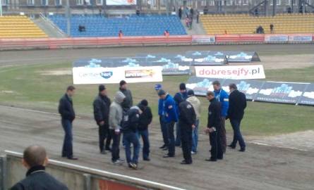 Zawodnicy i trener Caelum Stali Gorzów bacznie oglądają tor. Szczególnie interesuje ich odcinek startowy.