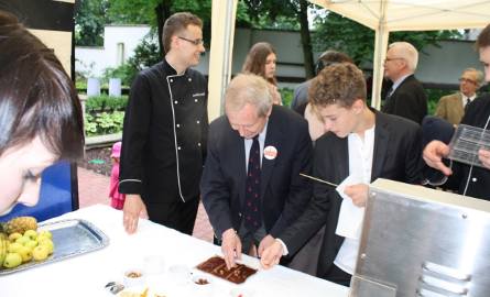 Janusz Onyszkiewicz przygotowuje sobie czekoladę na stoisku gminy Kargowa