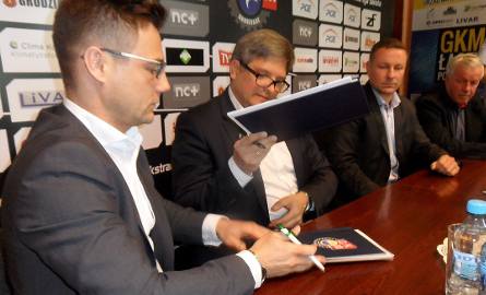 Pełnomocnicy prezesa MrGarden Adam Goliński,  ds. prawnych (z lewej) i Piotr Leszkowicz -  ds finansowych podpisują umowę o wejście w nazwę GKM. Brzmi