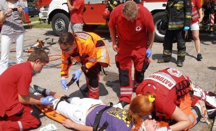 Młodzi ratownicy udzielają pomocy poszkodowanemu w wypadku.