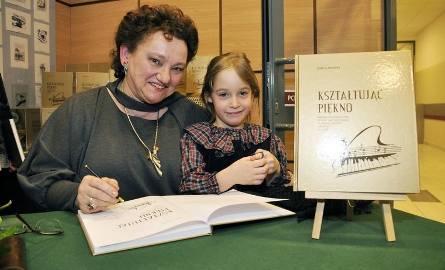 Izabella Mosańska podpisuje swą książkę, towarzyszy jej  mała Agatka