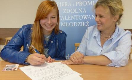 Weronika Więcław (z lewej) podpisuje umowę stypendialną w towarzystwie wiceprezes fundacji Daj Szansę Joanny Wężyk.