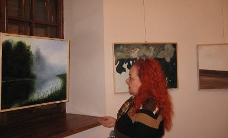 Beata Drozdowska ogląda obraz Michała Budzisza.
