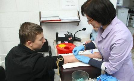 Szymon Zawłocki – uczeń klasy trzeciej techniku budowlanego po raz pierwszy oddawał krew. Próbkę krwi pobiera mu Elżbieta Rogozińska – starszy technik