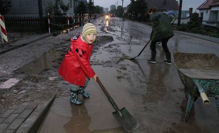 6-letni Bartek Banasik pomaga w sprzątaniu ulicy po ulewie w Porąbkach w gminie Bieliny.