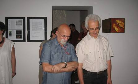 Profesor Aleksander Olszewski z profesorem ASP, Grzegorzem Bilińskim wpatrują się w zarysowaną podłogę