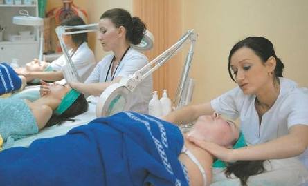 Jolanta Kopec wykonuje masaż twarzy, a w tle zwyciężczyni konkursu Anna Kowalczyk