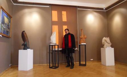 Jacek Michał Szpak przy swoich rzeźbach na wystawie w Sanoku.