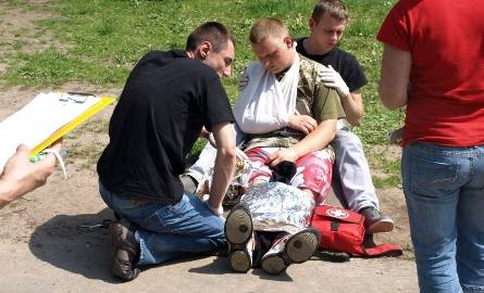 Młodzi ratownicy pomagają rowerzyście, który uległ poważnemu wypadkowi.
